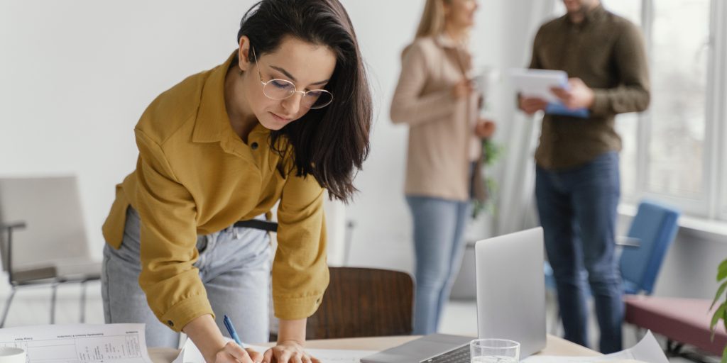 businesswoman-working-while-her-teammates-are-talking